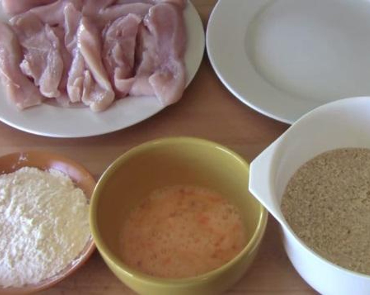 step 4 Take each chicken slice, and roll them in the flour, dip them in the egg mixture and finally roll them in the breadcrumb mixture. Then, Place the chicken strips on a separate plate, and let them chill for half an hour.