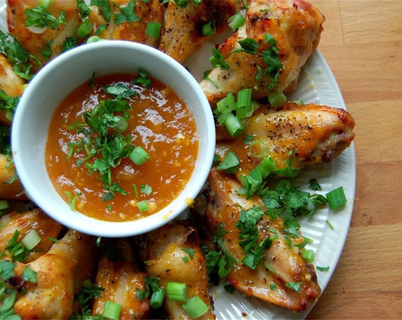 step 7 Arrange wings on a platter. Garnish with sliced green part of Scallions (to taste) and Fresh Cilantro (to taste). Thin the reserved Just Jan's Mango Chipotle Spread with a few teaspoons of water, and place in a small bowl for dipping.