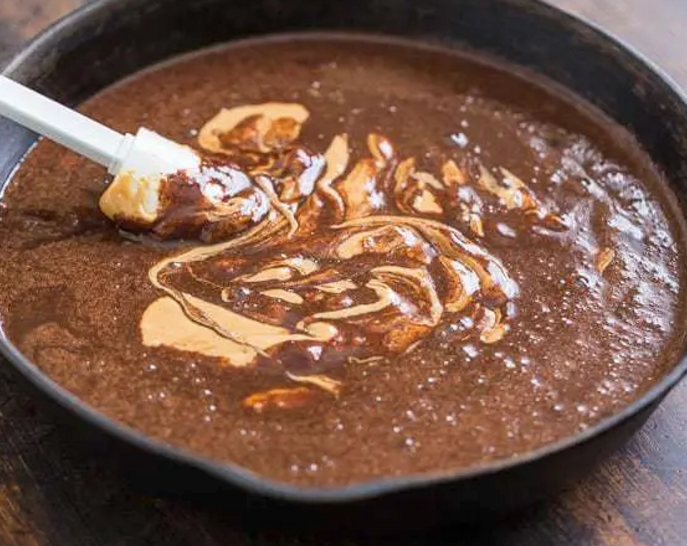 step 3 Whisk in the Almond Butter (1 cup), Baking Powder (1/2 tsp), Eggs (2), Maple Syrup (3/4 cup), and Unsweetened Cocoa Powder (1/2 cup), one at a time, taking care not the get the mixture too hot, you don`t want to scramble the eggs.