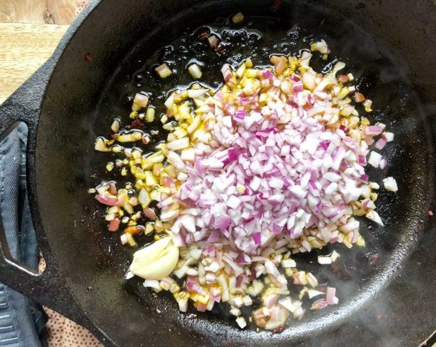 step 5 In that same skillet, heat Extra-Virgin Olive Oil (2 Tbsp). Add the Red Onion (1), Garlic (1 clove), and Kosher Salt (1/2 tsp). Cook, stirring frequently, over medium heat for about 5 minutes until the onion is soft and translucent.