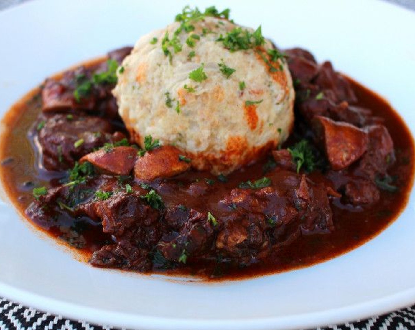 step 12 To serve, place one dumpling on a deep plate, surround the dumpling with the meat, mushrooms and sauce, and granish with additional parsley if desired.