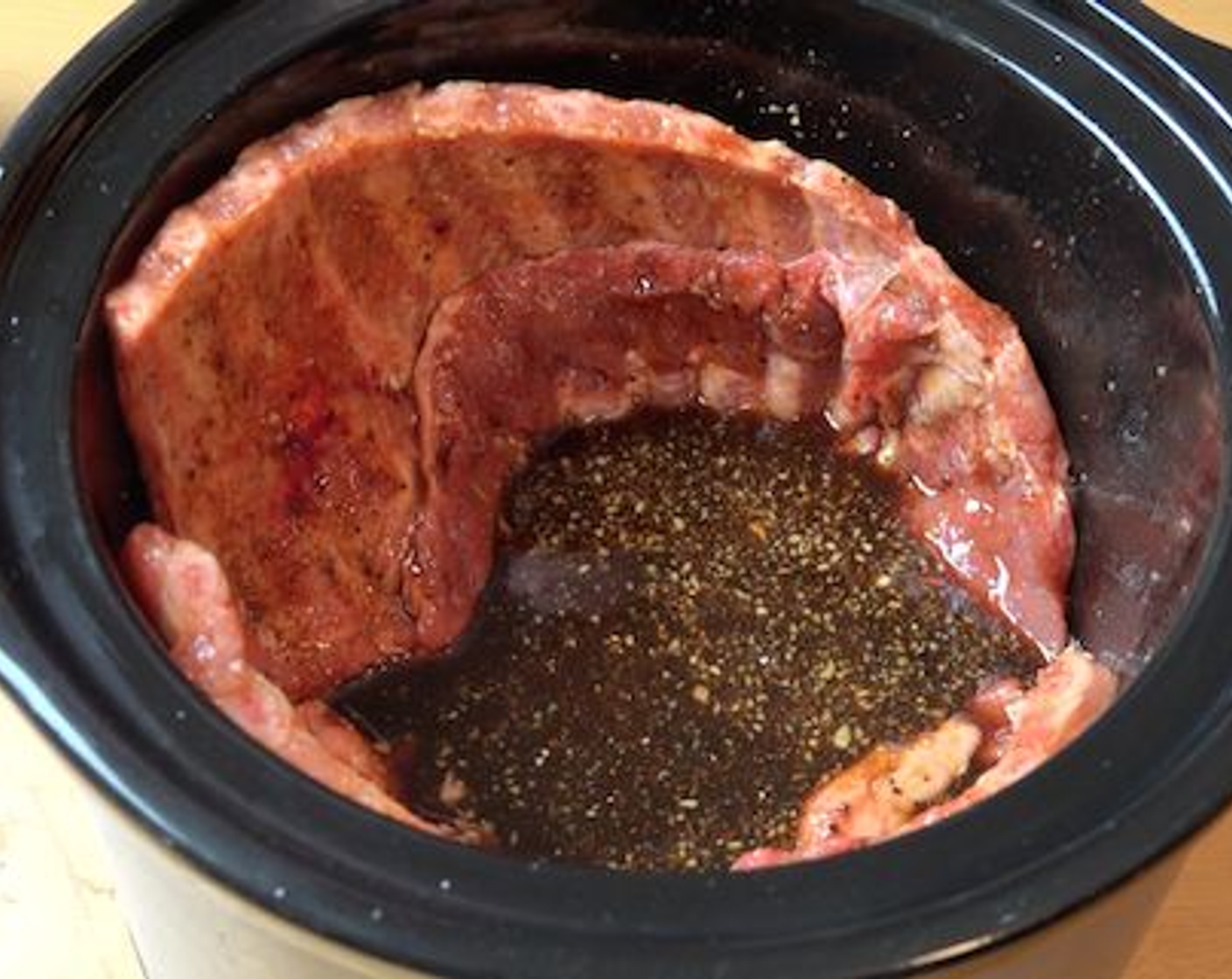 step 3 Next, add your pork ribs into the slow cooker and dredge into the sauce and turn to make sure they are well coated with the sauce all over. Place them meat side out on the edge of the cooker making sure the bones are facing up and inward.