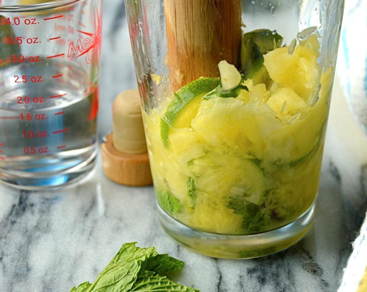 step 3 Thinly slice the Lime (1/2). Add the Fresh Pineapple Chunk (1 cup), lime slices and Fresh Mint Leaves (10) to a large cocktail shaker or pitcher.  Using a muddler, crush the pineapple, lime and mint leaves until fragrant.