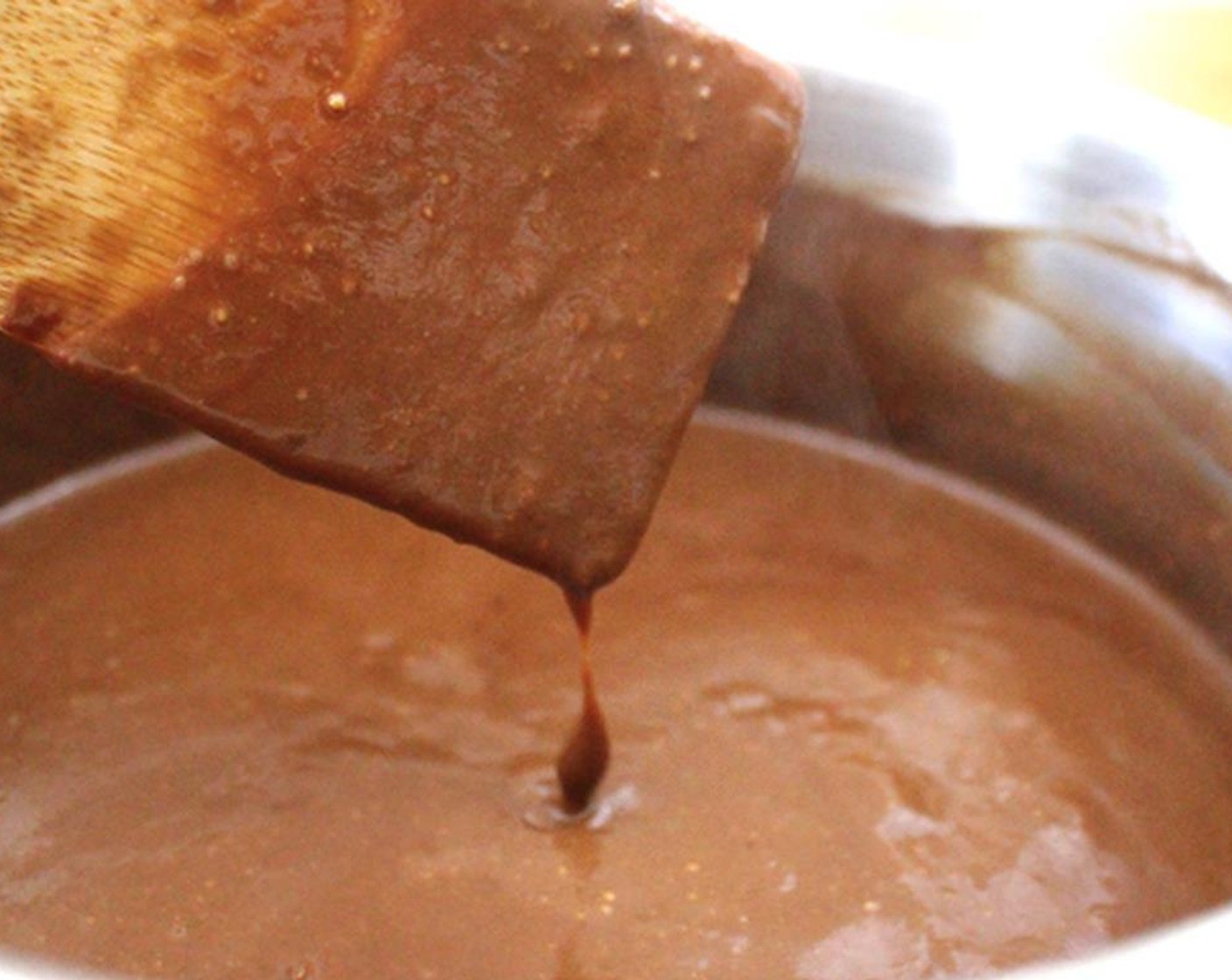 step 9 Let an ice cube melt in the bottom of a clean pot (this keeps the milk from scalding). Add the cornstarch mixture, Salt (1 pinch), Honey (3 Tbsp), and Milk (480 mL) and warm slowly, over medium heat, stirring occasionally.