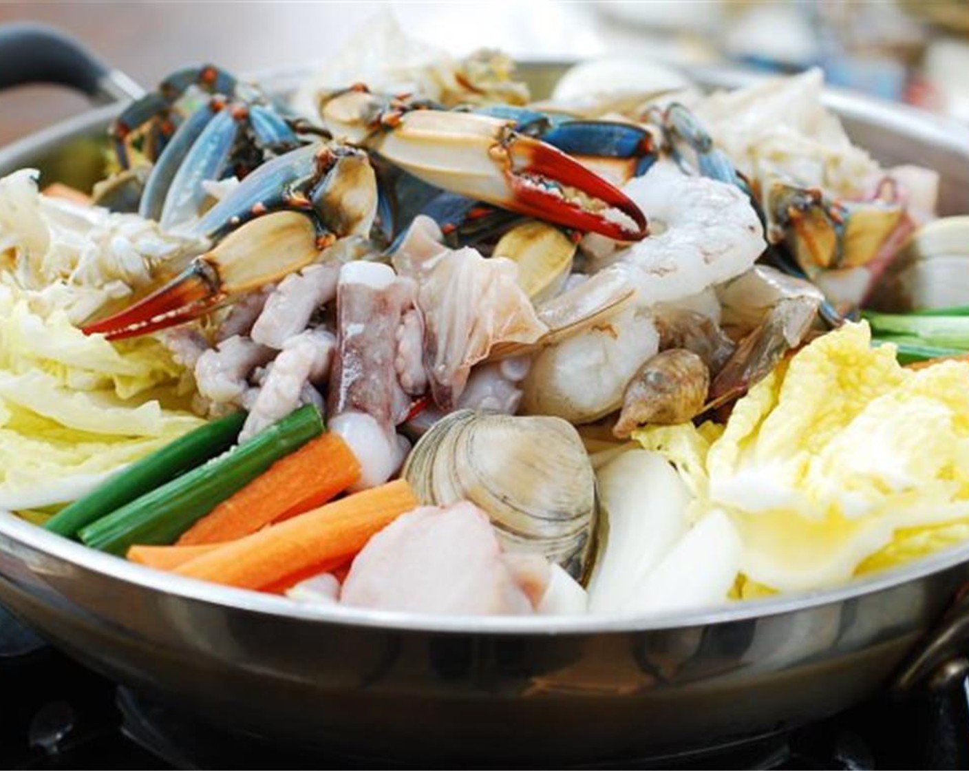 step 5 Using a wide, shallow pot, neatly arrange the cut vegetables and Soybean Sprouts (1 1/2 cups) in clusters, with the exception of the watercress (or crown daisy). Scatter the seafood pieces on top of vegetables, placing the clams/mussels closer to the bottom of the pan.