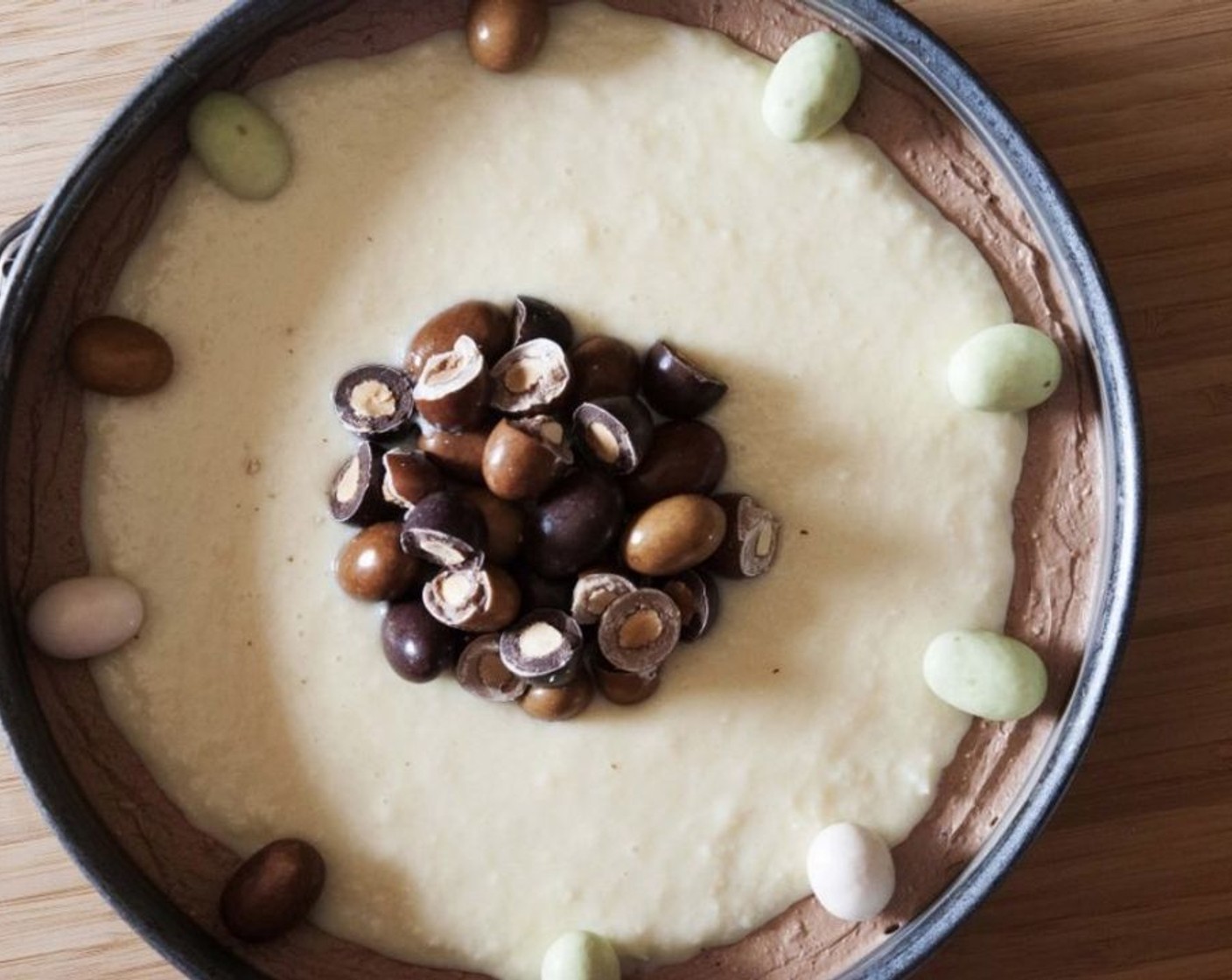 step 8 Spread the cream right in the center of your cheesecake, leaving a little bit of an edge. Decorate with Cadbury Mini Easter Egg Candies (to taste).